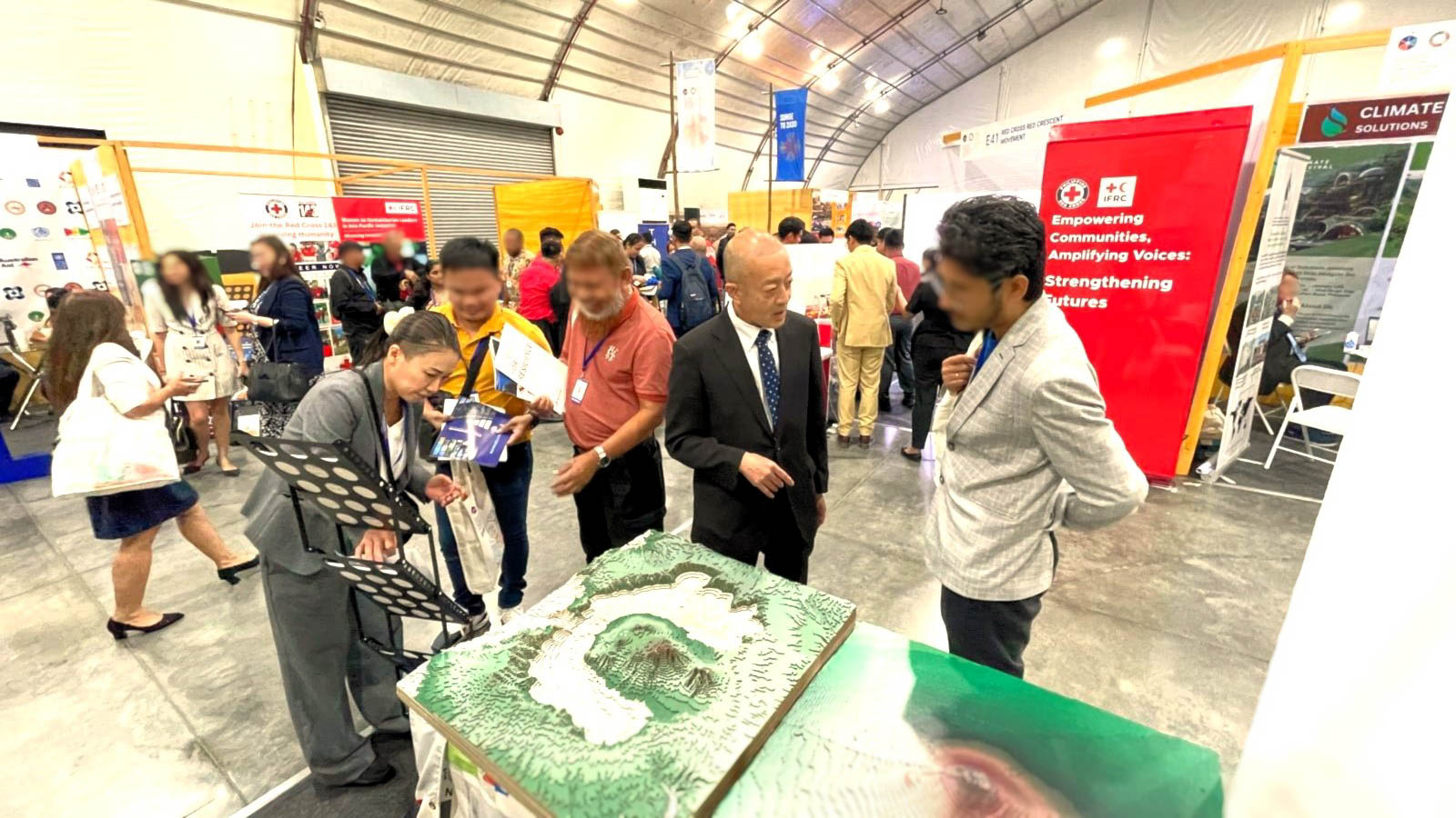 NIED staff explaining to visitors using diorama models of an active volcano in Japan