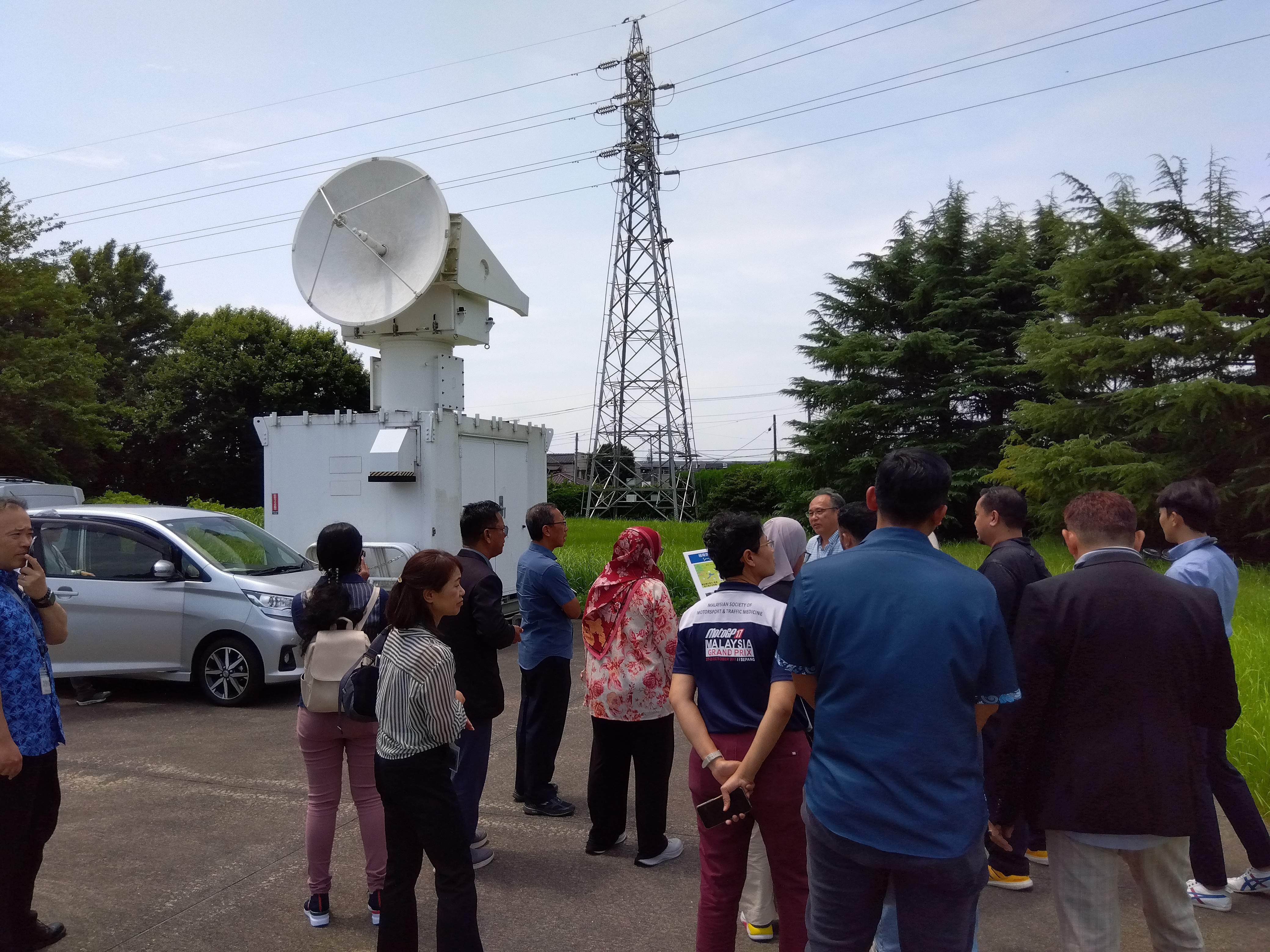 Dr. IIZUKA explains NIED's meteorological observation radars at the radar site.