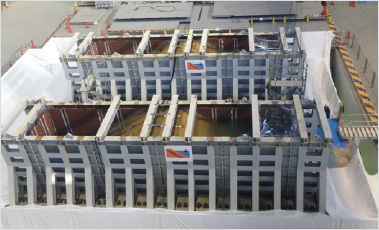 Photo of an experiment to determine how to prevent damage from earthquake breakdowns when installing impervious sheets inside a levee for the purpose of intercepting water in a reservoir.い